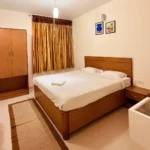 Aerial view of hillside cottages amidst lush greenery at the best stays in Ooty.