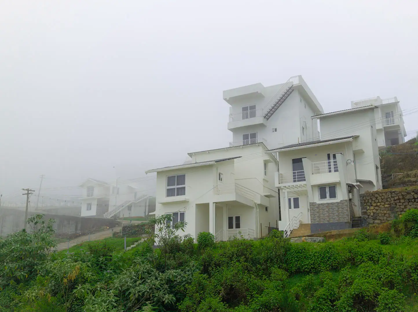 Guests reading books beside a window with mountain views at the best stays in Ooty.