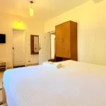 Couple sitting near a bonfire outside a cottage at the best stays in Ooty.